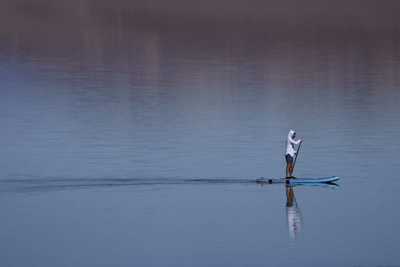A paddle boarder paddles through water at Badwater Basin, Thursday, Feb. 22, 2024, in Death Valley National Park, Calif. The basin, normally a salt flat, has filled from rain over the past few months. (AP Photo/John Locher)